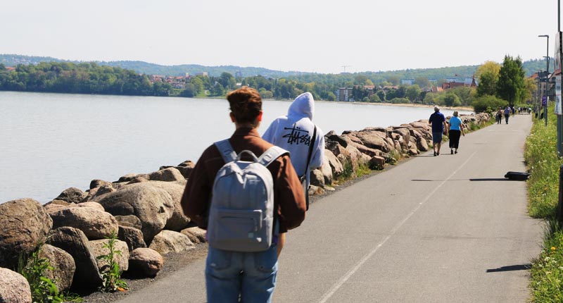 Människor som går på gångbana utmed Vätterstranden.