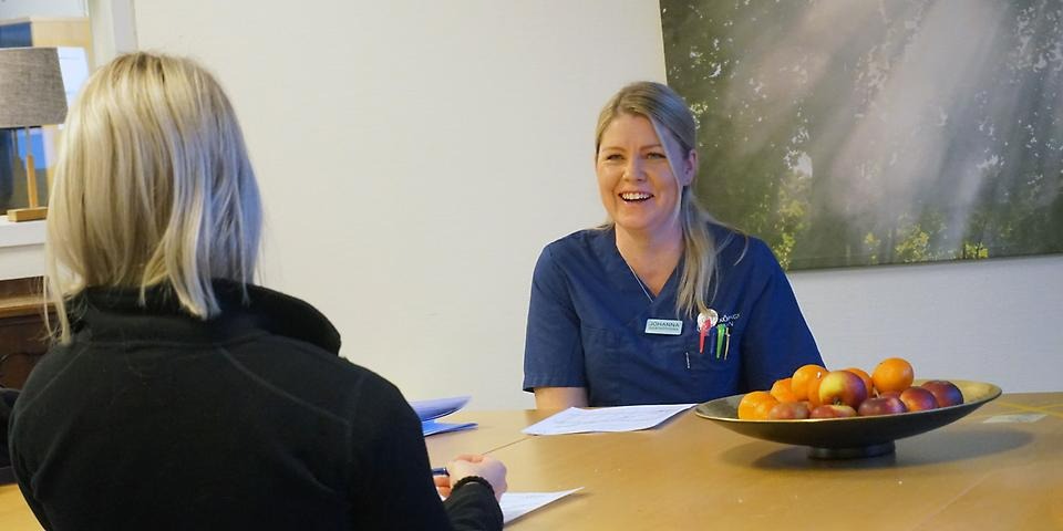 Johanna Metsäranta, sjuksköterska i hälso- och sjukvårdsfunktionen skrattar i samtal med medborgare.