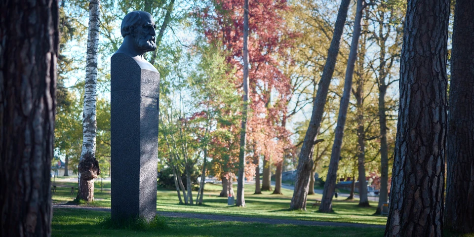 Skulpturen sedd från sidan omgiven av tallar.