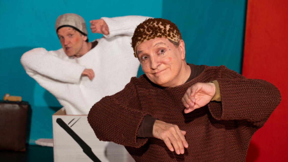 Vem räddar Alfons Åberg (barnteater). Två skådespelare, varav en föreställer Alfons, syns på bilden. De håller upp sina armar och tittar mot publiken.
