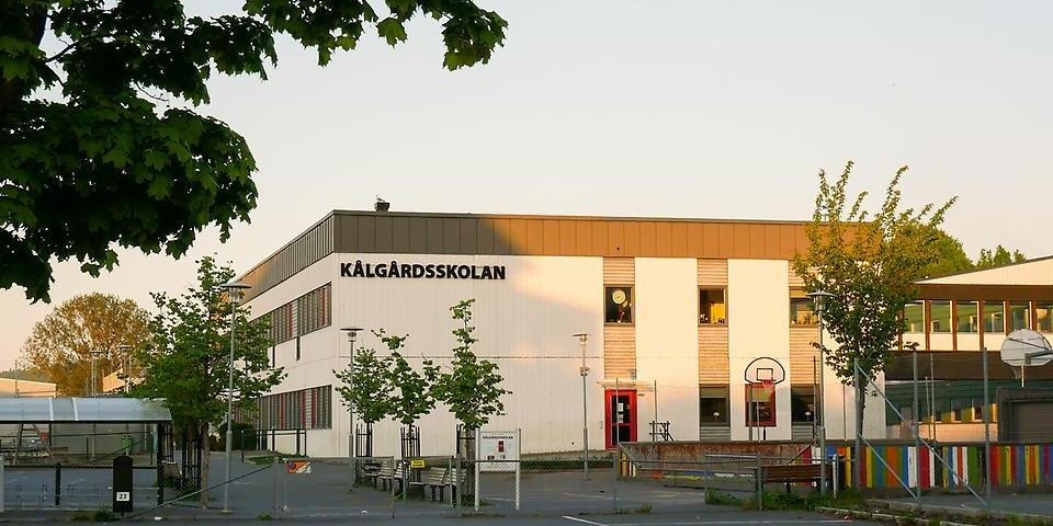 Kålgårdsskolan sett från utsidan med ett träd i förgrunden.
