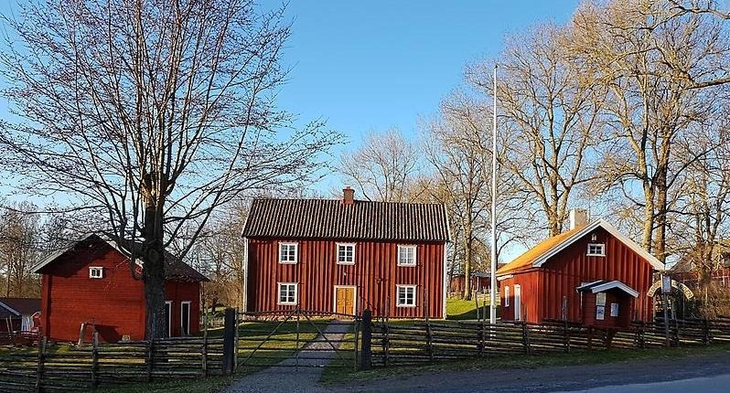 Tre röda hus i olika storlekar.