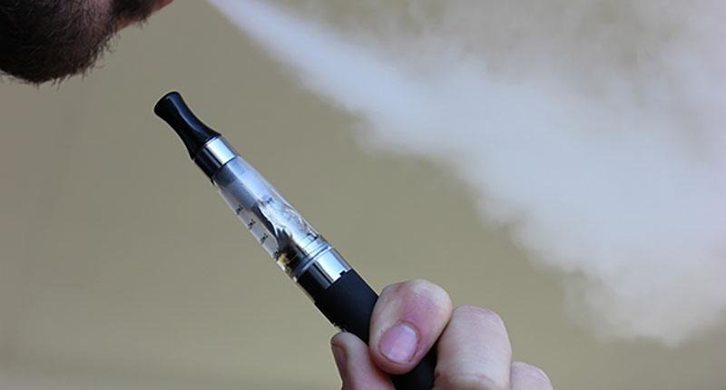 Person som röker e-cigarett.