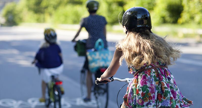 Tre personer som cyklar med ryggen mot kameran.