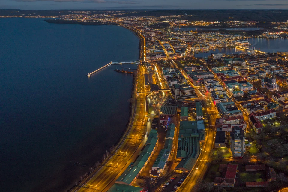 Vybild över centrala Jönköping och dess Vätterstrand i skymningen.
