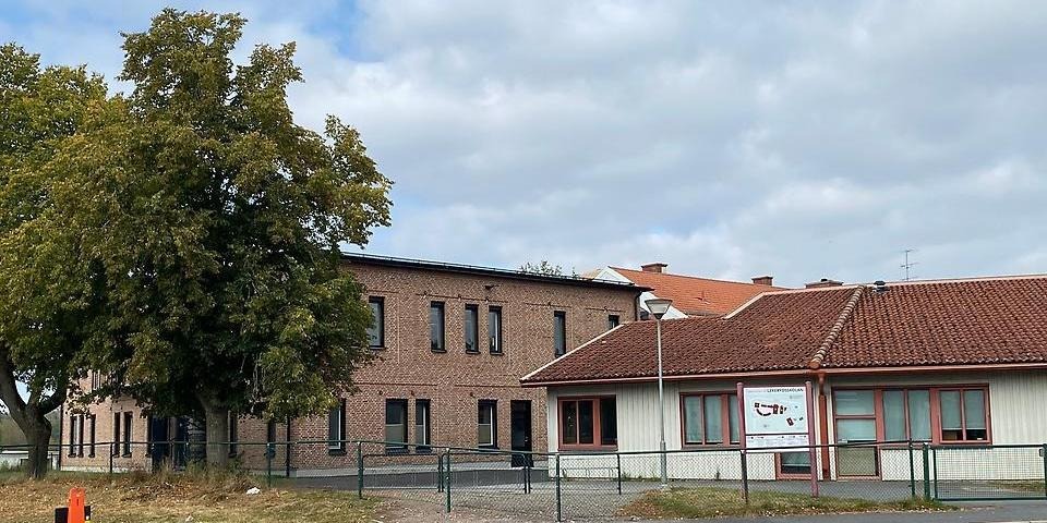 Lekerydsskolan sedd utifrån med ett stort träd i förgrunden.
