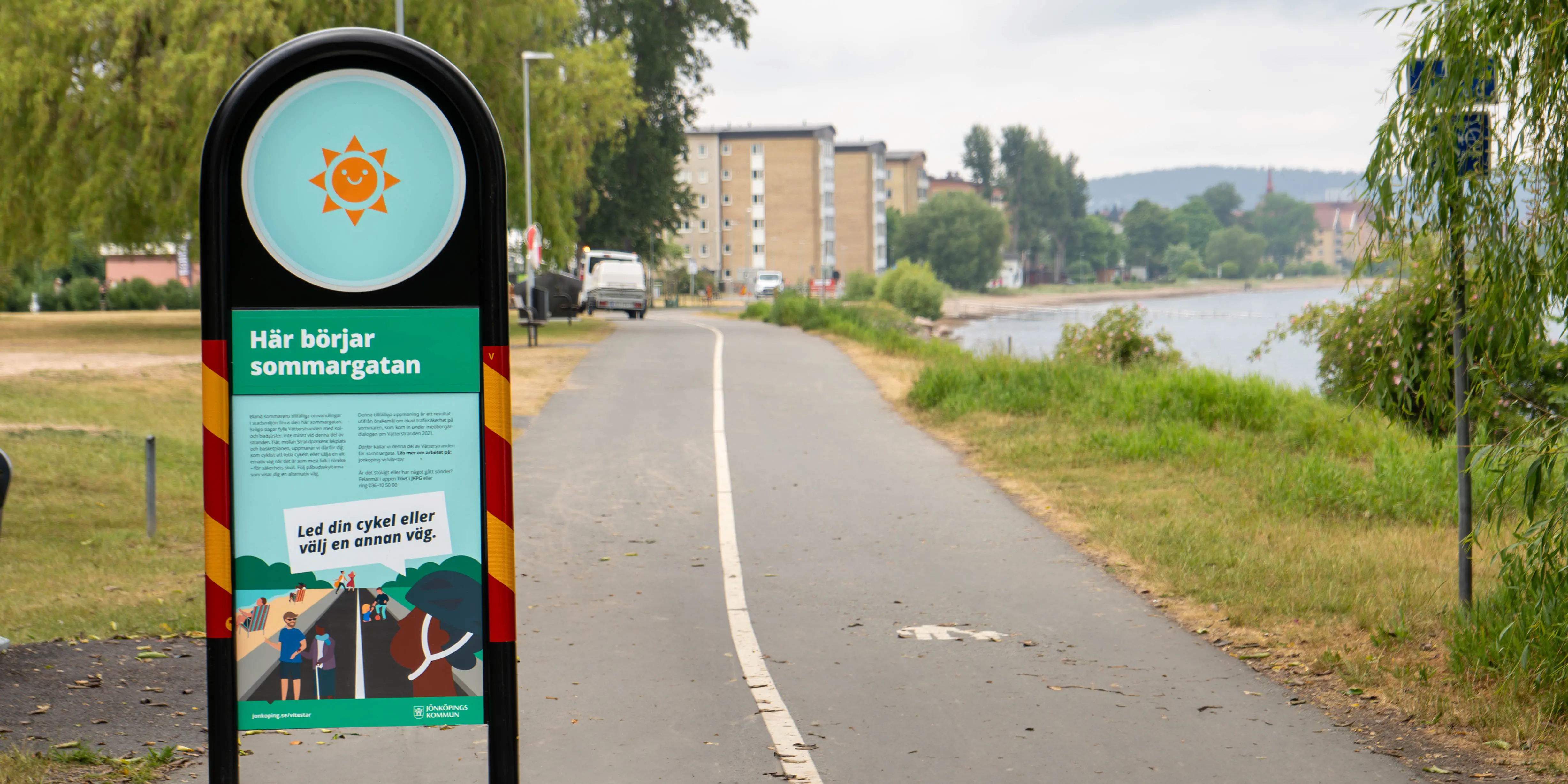 En skylt med illustrationer som visar en sol och människor i rörelse och informationstext.