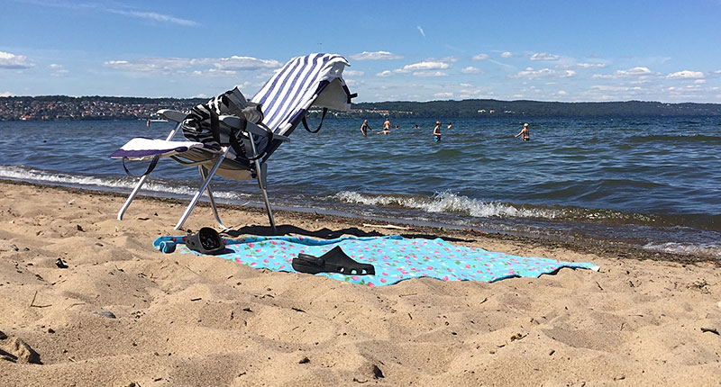 En varm dag på Vätterstranden, människor som badar.