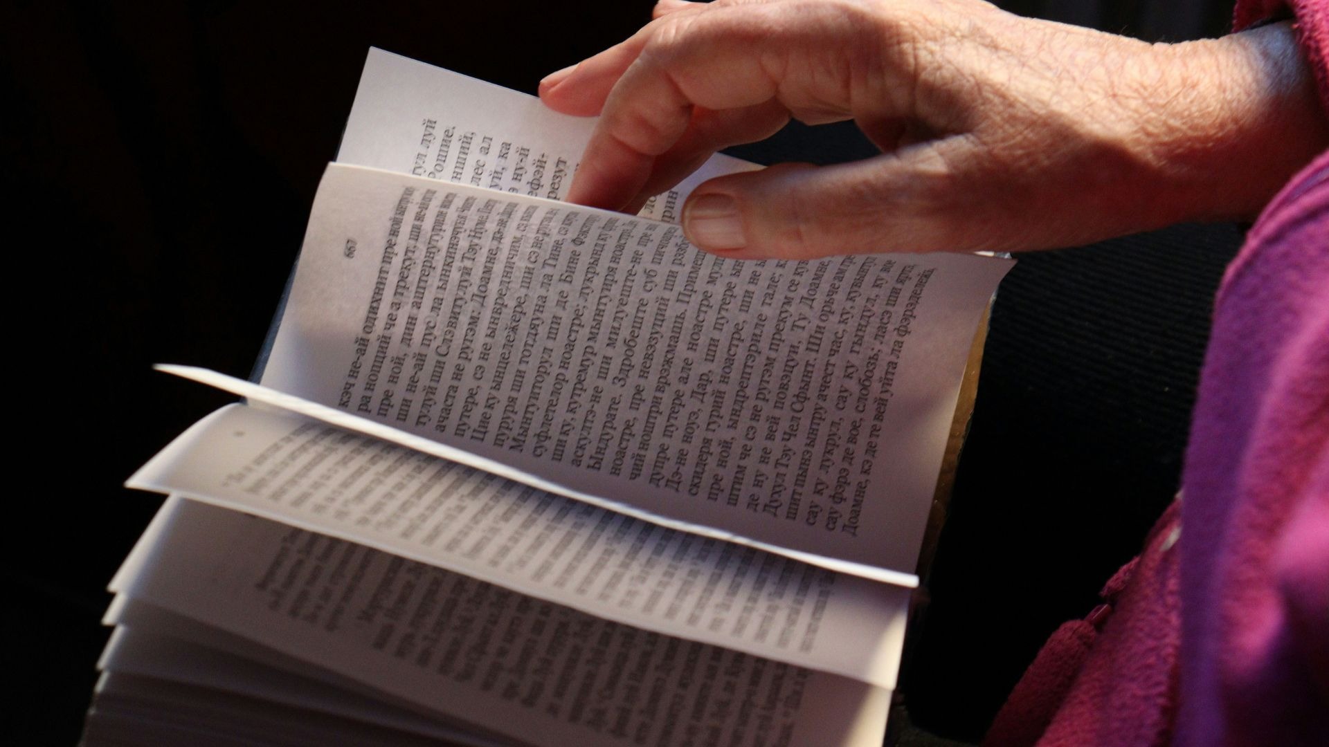 Hand som bläddrar i en bok.