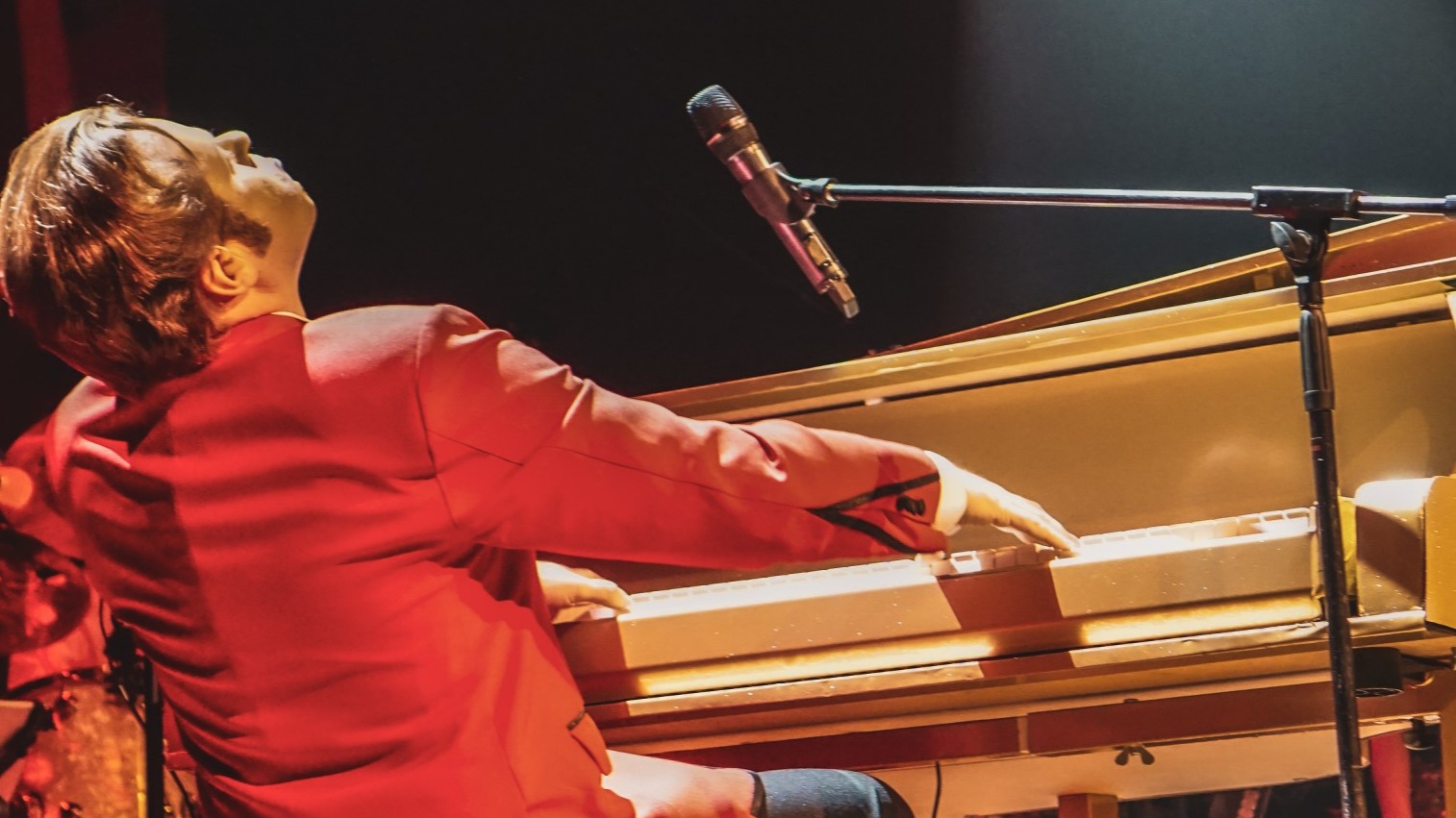en man som sitter vid ett piano