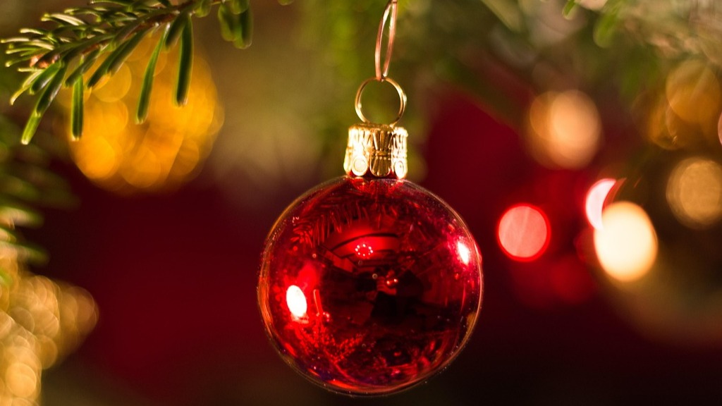 Röd julgranskula som hänger i en gran
