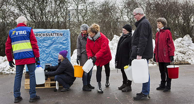 Människor som står i kö för att hämta dricksvatten i ett strömlöst samhälle.  Foto: Thomas Henrikson, MSB.