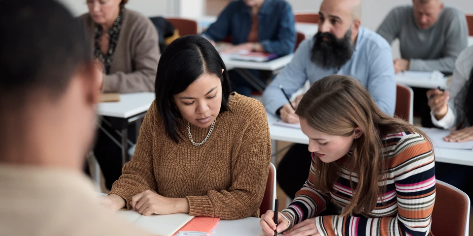 Vuxenutbildning i klassrum med flera personer.