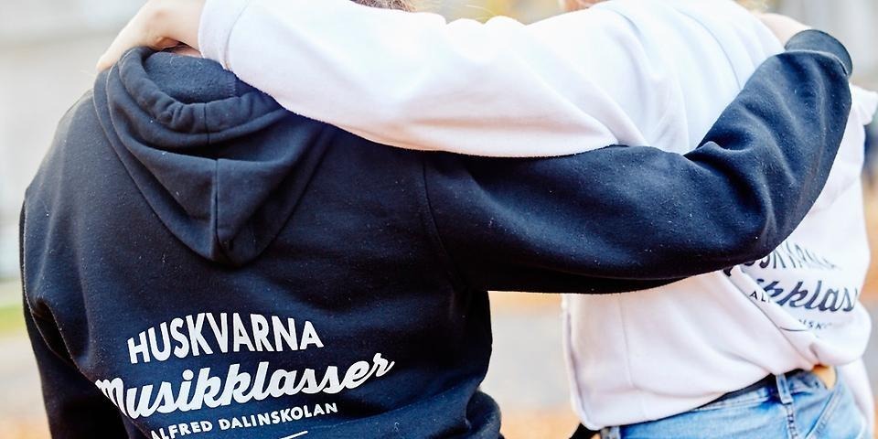 Två personer som håller om varandras axlar.