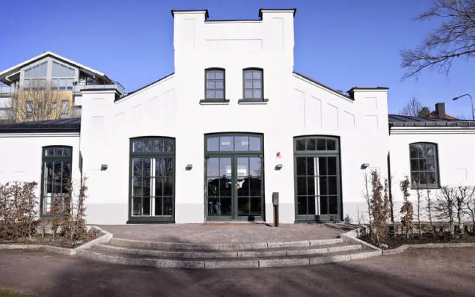 Byggnad med kantiga former och stora fönster och glasdörrar.