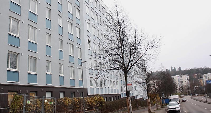 Stort flerbostadshus i grått och blått.