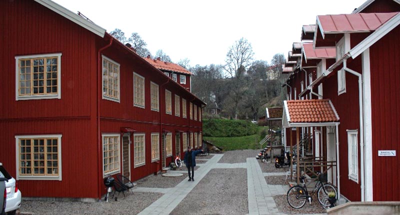 Två mindre röda flerbostadshus i äldre och traditionell småstadsstil.