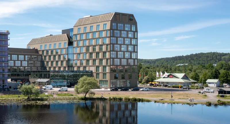 Stor kontorsbyggnad med stora fönsterpartier intill Munksjön.