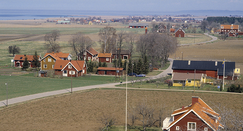 Översikt på Visingsö med hur och grönt med vattnet i bakgrunden.