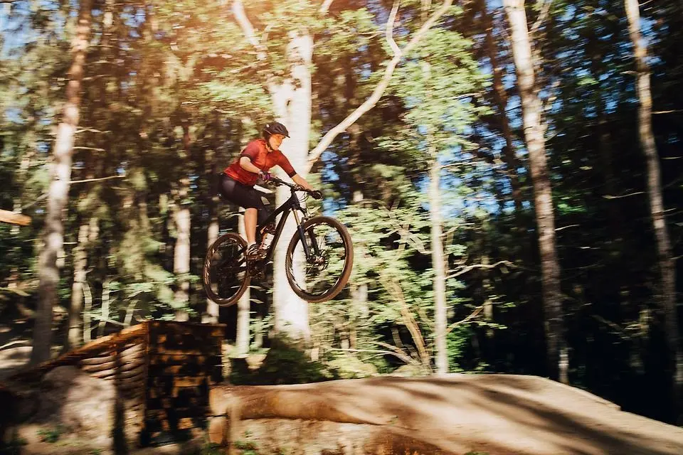 En person på en mountainbike hoppar i ett hopp.
