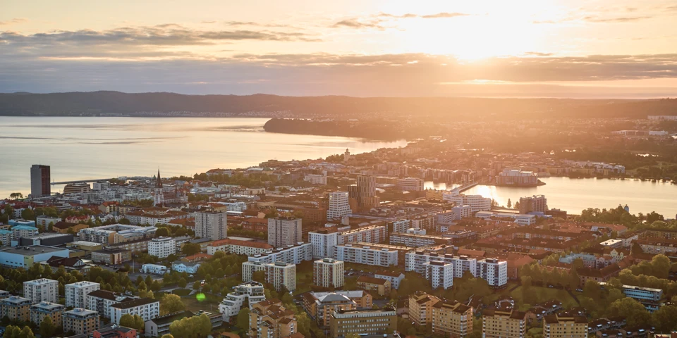 Vy över Jönköpings stadskärna där stad, Munksjön och Vätterns syns under en blå himmel med vita moln.