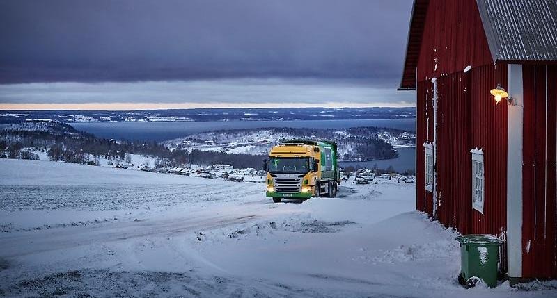 sopbil som kör i snötäckt vinterlandskap.