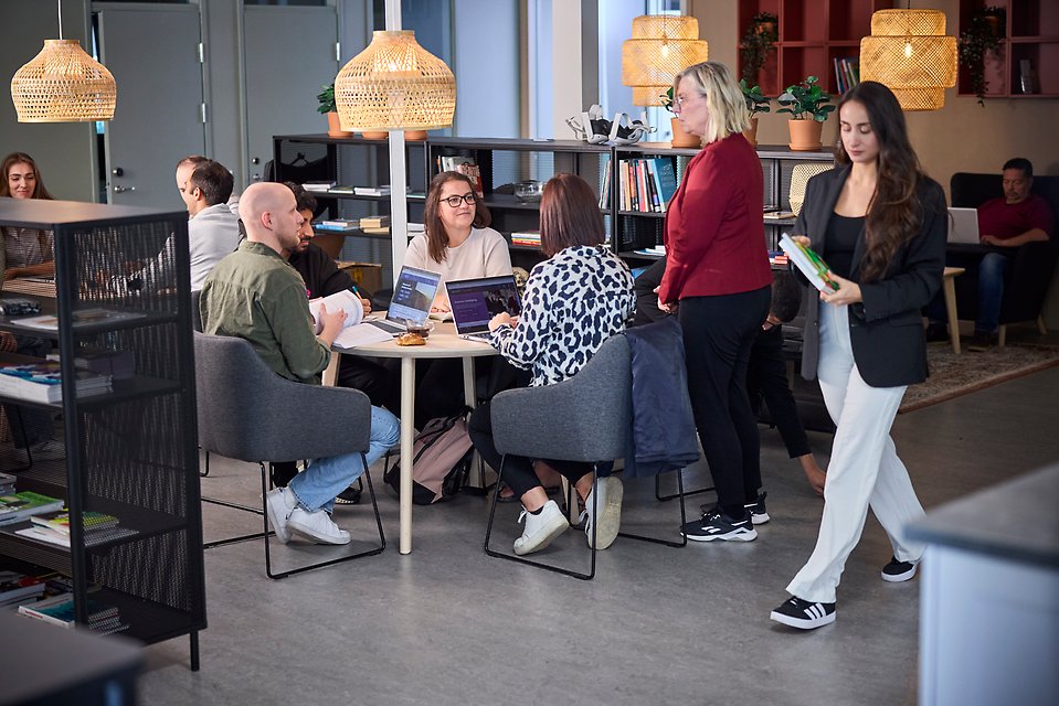 Studie- och yrkesvägledare som samtalar med en grupp sittande kvinnor och män